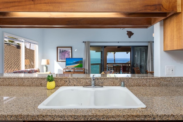 kitchen with a sink and beamed ceiling