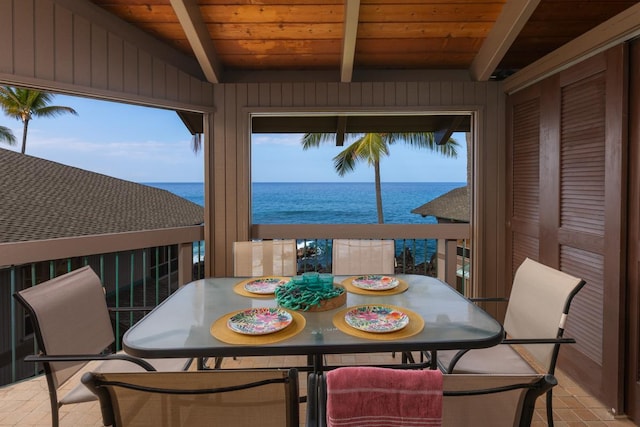 interior space with plenty of natural light, a water view, and beamed ceiling