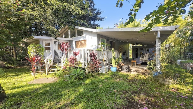 back of house featuring a carport