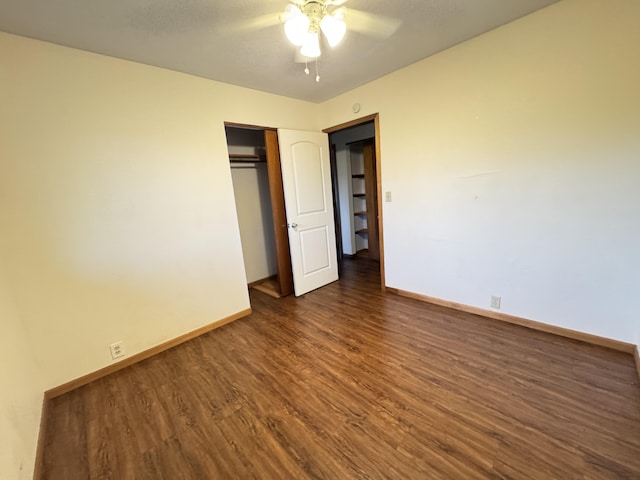 unfurnished bedroom with a closet, dark wood-style flooring, baseboards, and a ceiling fan