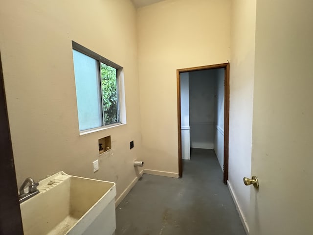 clothes washing area with laundry area, baseboards, washer hookup, and a sink