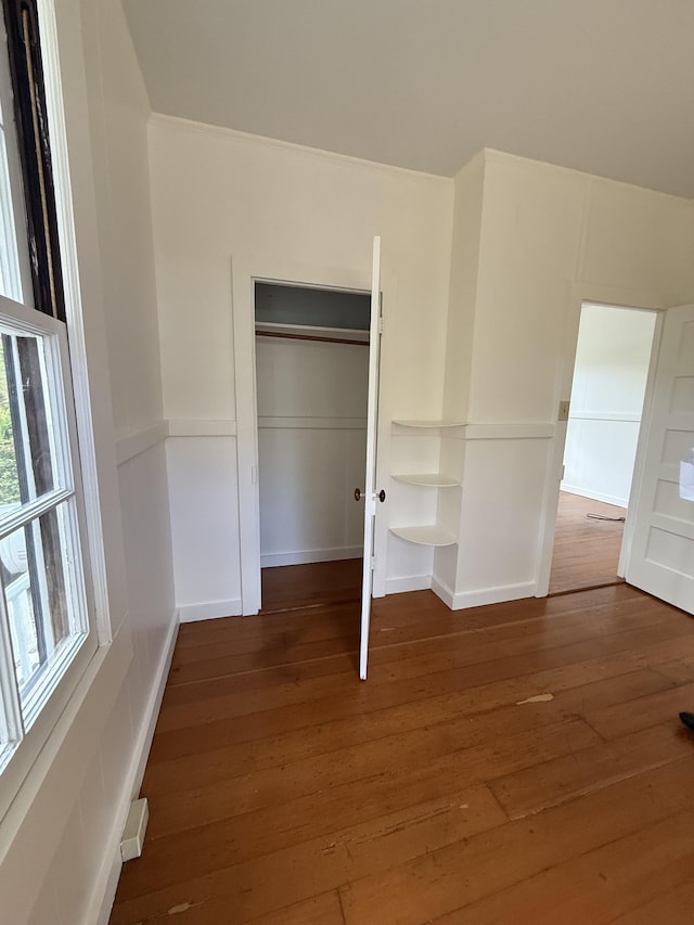 unfurnished bedroom featuring dark hardwood / wood-style flooring and a closet