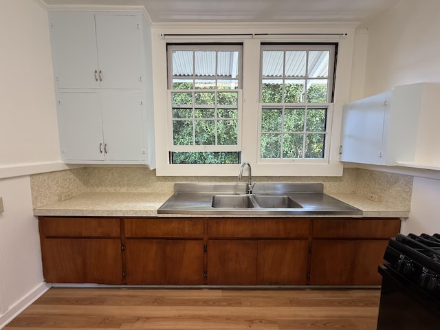 kitchen featuring white cabinetry, sink, black range with gas stovetop, and tasteful backsplash