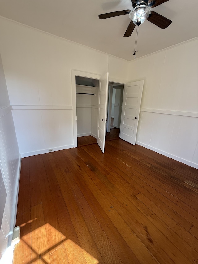 unfurnished bedroom with a closet, dark hardwood / wood-style floors, and ceiling fan