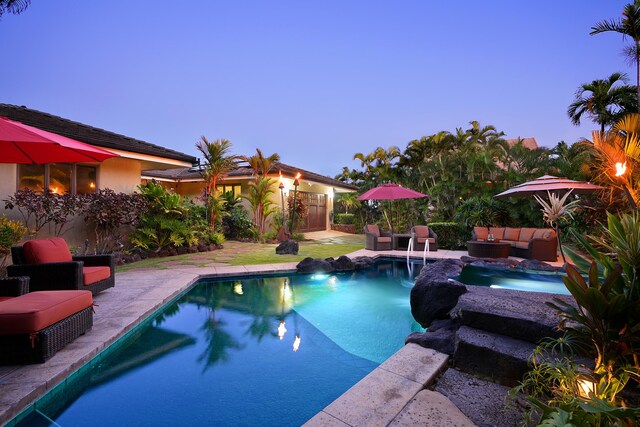 pool at dusk with a patio, an outdoor living space, and an outdoor pool