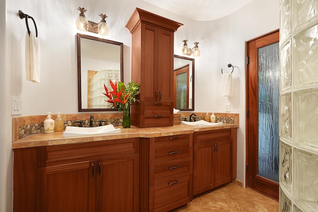 full bathroom with a sink and double vanity