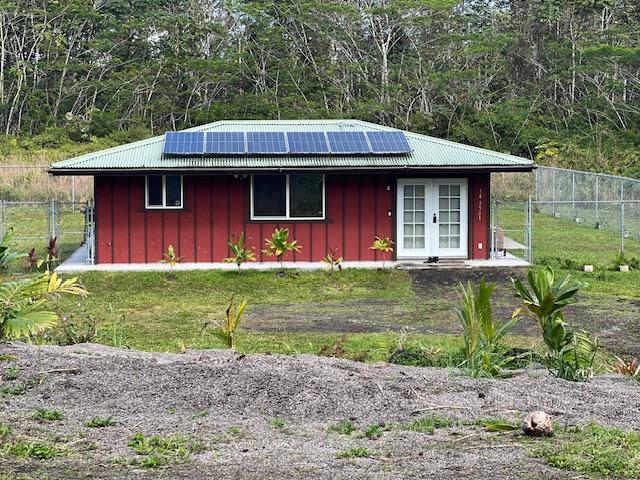 view of outdoor structure featuring french doors, fence, solar panels, and a gate