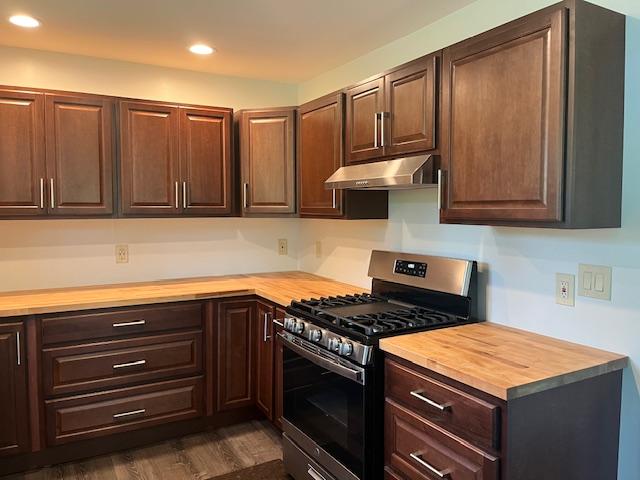 kitchen with gas range, butcher block counters, and dark hardwood / wood-style flooring