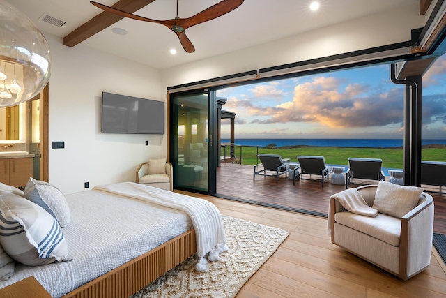 bedroom with multiple windows, access to outside, beam ceiling, and light hardwood / wood-style flooring