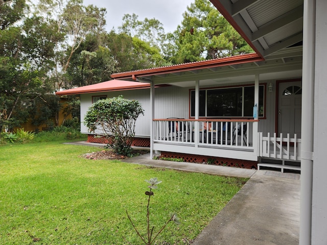 doorway to property with a yard and a porch