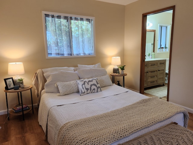 bedroom with connected bathroom and dark hardwood / wood-style flooring