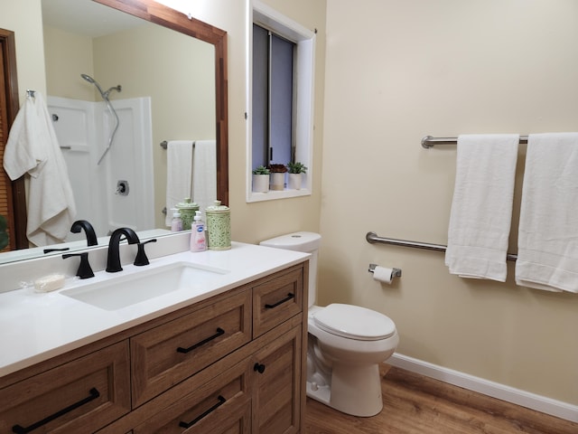 bathroom with vanity, hardwood / wood-style floors, walk in shower, and toilet