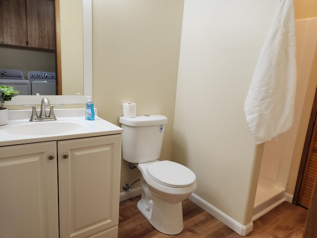 bathroom with vanity, wood-type flooring, toilet, and washing machine and clothes dryer