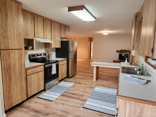 kitchen featuring sink, light wood-type flooring, light brown cabinets, and appliances with stainless steel finishes