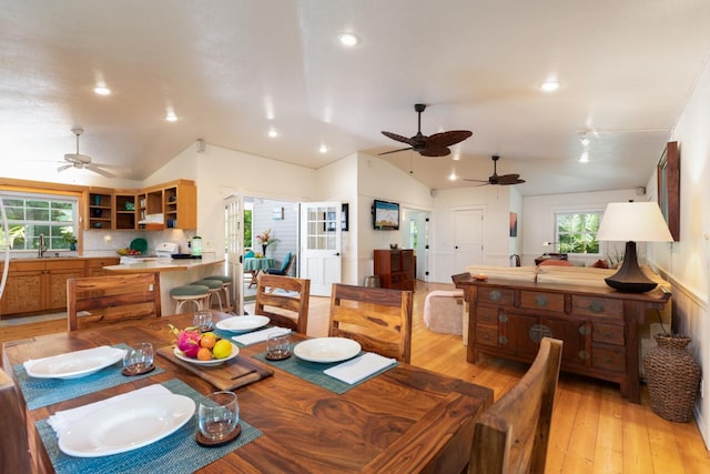 dining area featuring lofted ceiling, a wealth of natural light, and light wood-type flooring