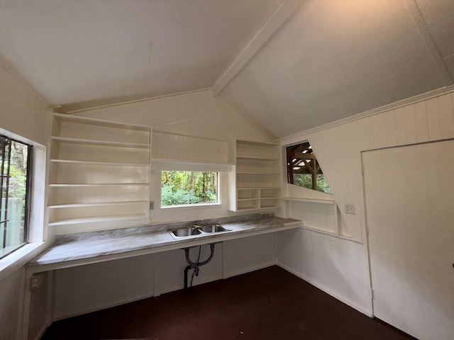 kitchen with sink, built in features, built in desk, and vaulted ceiling with beams