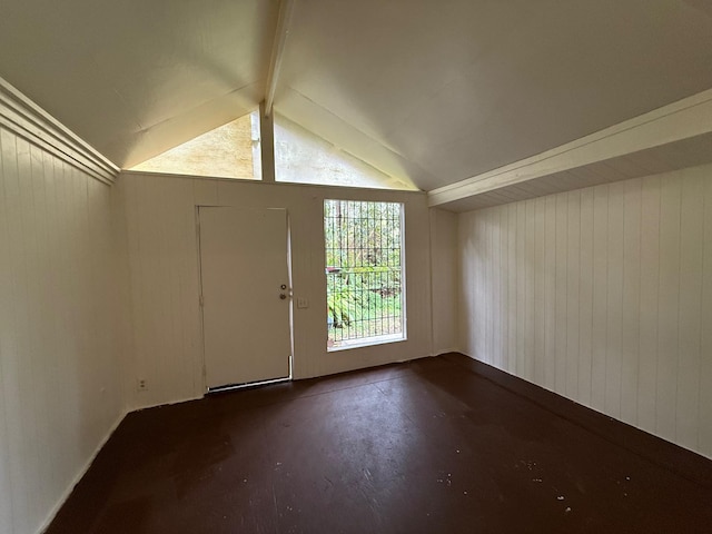 foyer featuring vaulted ceiling with beams and concrete flooring