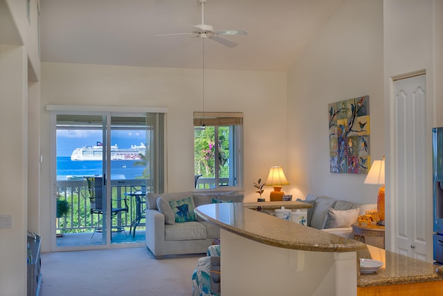 carpeted living room with high vaulted ceiling and ceiling fan