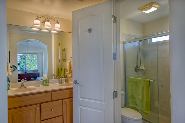 bathroom with an enclosed shower, vanity, and toilet