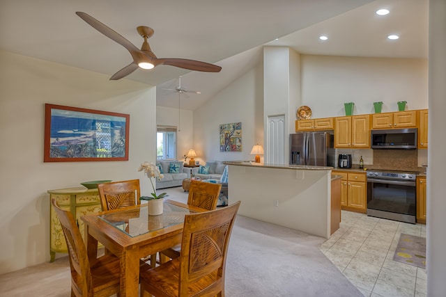 dining room with ceiling fan and high vaulted ceiling