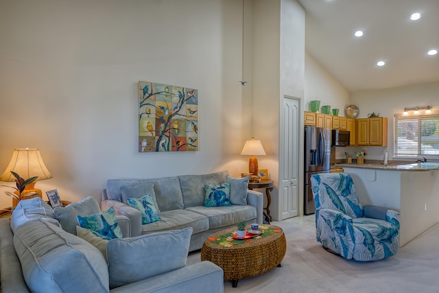 carpeted living room with high vaulted ceiling