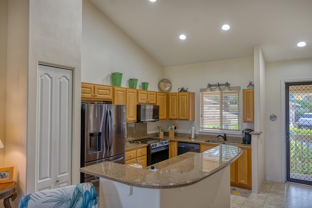 kitchen featuring light tile patterned floors, a breakfast bar area, light stone counters, black appliances, and a kitchen island