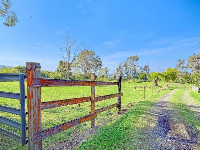 view of gate with a yard and a rural view