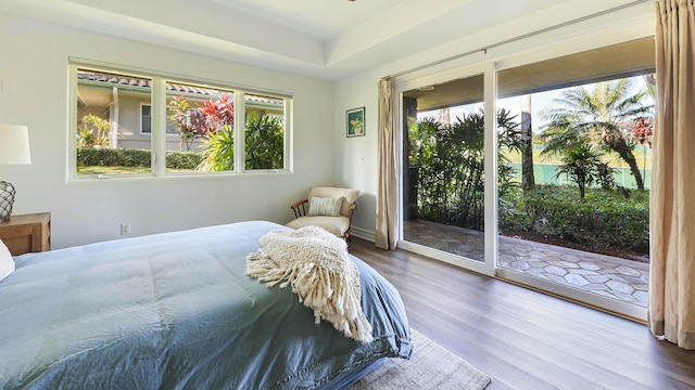 bedroom with access to outside and wood finished floors