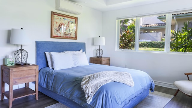 bedroom featuring an AC wall unit, baseboards, and dark wood-style flooring