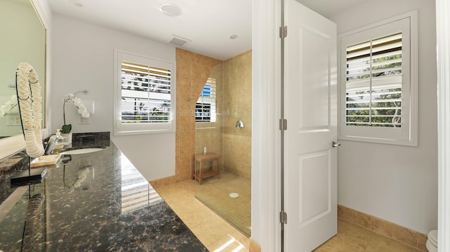 bathroom with vanity, baseboards, a walk in shower, and tile patterned floors