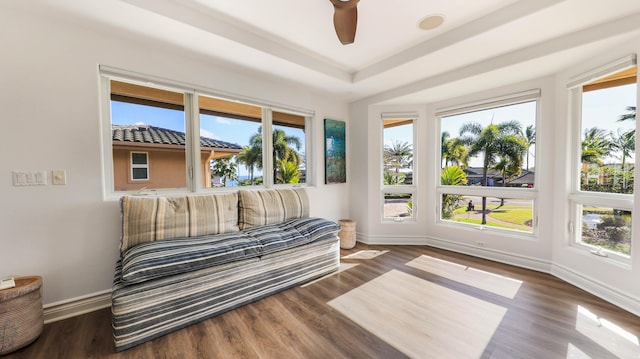 sunroom / solarium featuring a ceiling fan and a raised ceiling