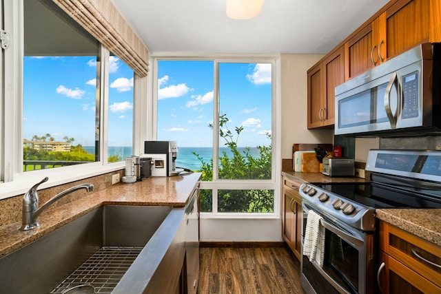 kitchen with a water view, stainless steel appliances, sink, and a wealth of natural light