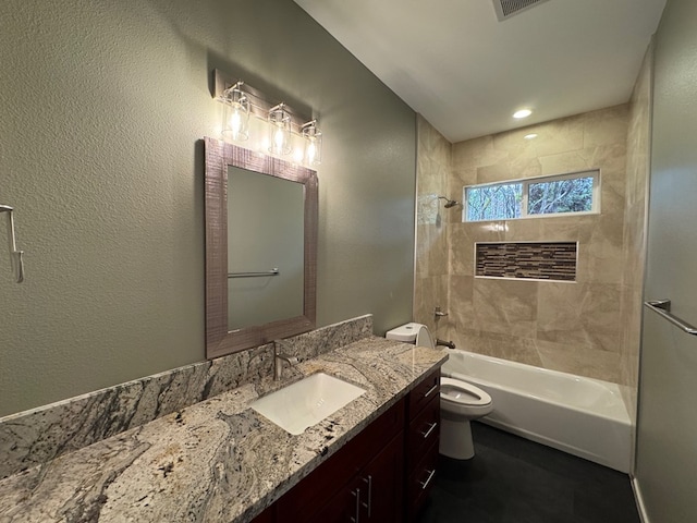 full bathroom featuring tiled shower / bath combo, vanity, and toilet