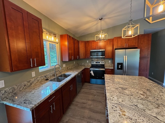 kitchen featuring stainless steel appliances, decorative light fixtures, light stone countertops, and sink