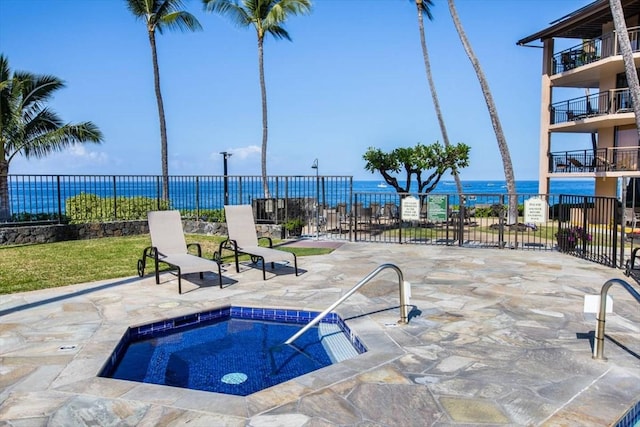 view of swimming pool featuring a water view, a hot tub, and a patio