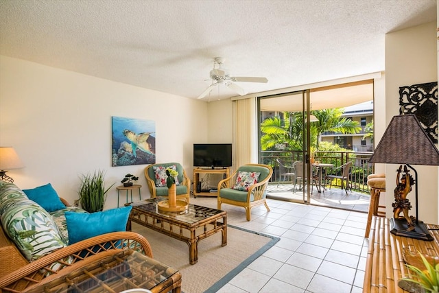 tiled living room with ceiling fan, a textured ceiling, and a wall of windows