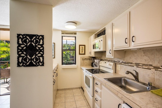 kitchen with tasteful backsplash, white cabinetry, sink, light tile patterned floors, and white appliances