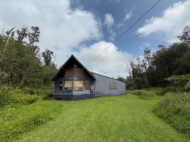 rear view of property featuring a lawn