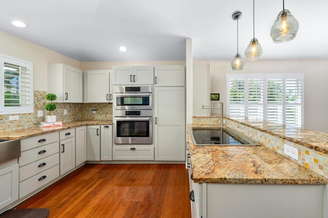 kitchen featuring white cabinetry, double oven, decorative backsplash, dark hardwood / wood-style flooring, and decorative light fixtures