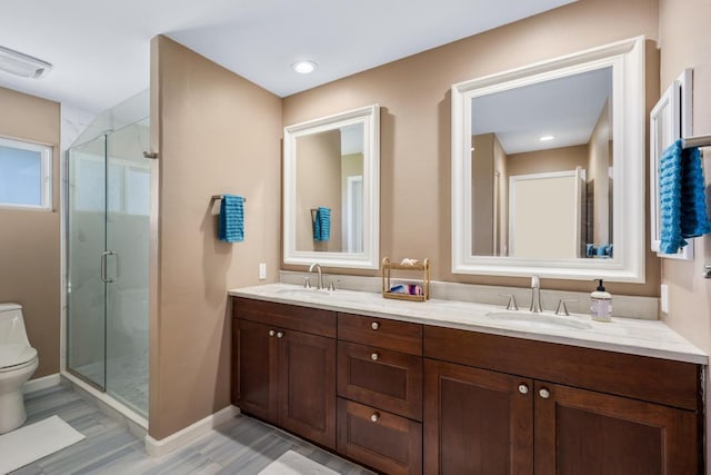 bathroom with vanity, toilet, and a shower with shower door