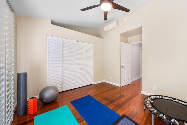 exercise area featuring hardwood / wood-style flooring, ceiling fan, and vaulted ceiling