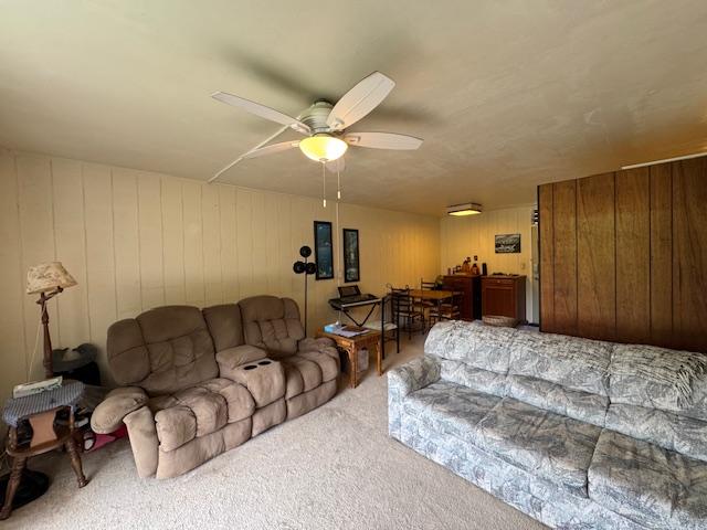 carpeted living room featuring ceiling fan