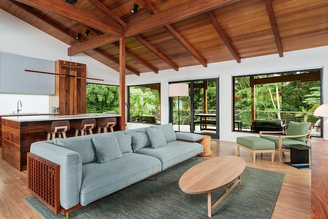 sunroom / solarium featuring vaulted ceiling with beams, wood ceiling, and sink