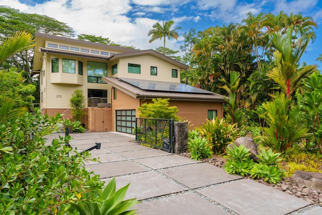 view of front of property with a garage and solar panels