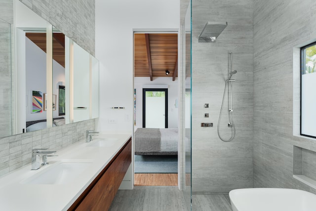 bathroom featuring hardwood / wood-style floors, vanity, plenty of natural light, and a tile shower