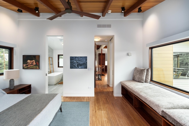 bedroom with connected bathroom, beam ceiling, wooden ceiling, and light wood-type flooring