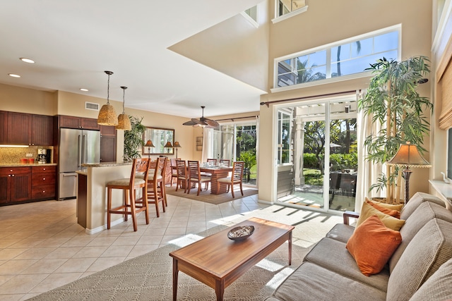 tiled living room featuring a towering ceiling and ceiling fan