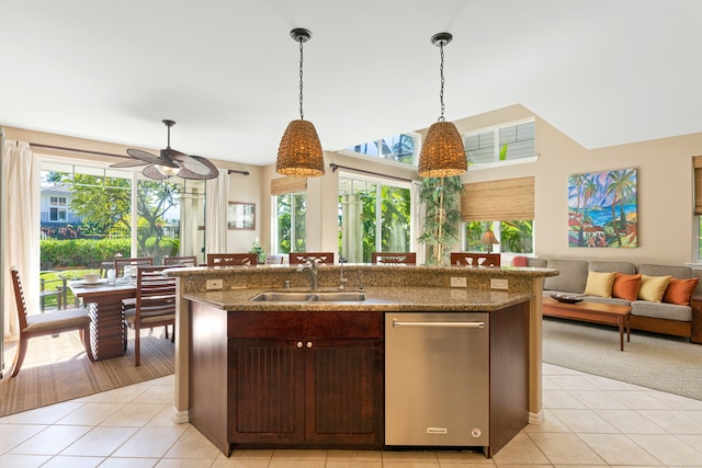 kitchen featuring sink, stainless steel dishwasher, dark brown cabinetry, and light tile patterned floors