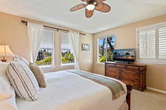 carpeted bedroom featuring multiple windows and ceiling fan