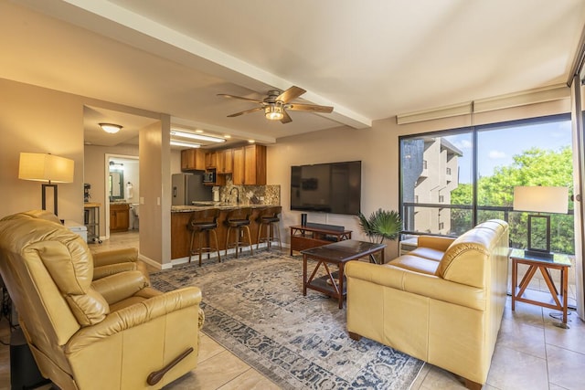 tiled living room with ceiling fan and beam ceiling